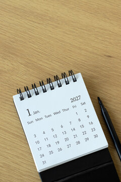 January first 2027 calendar year on a wooden background. Copy space.