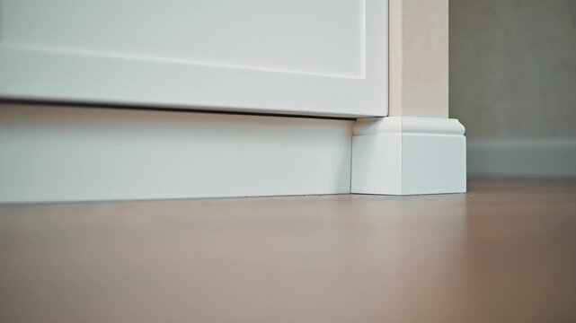 Close-up views of a baseboard meeting the floor, highlighting gaps and joints from various angles. The focus is on the clean lines and the contrast between the white baseboard and floor