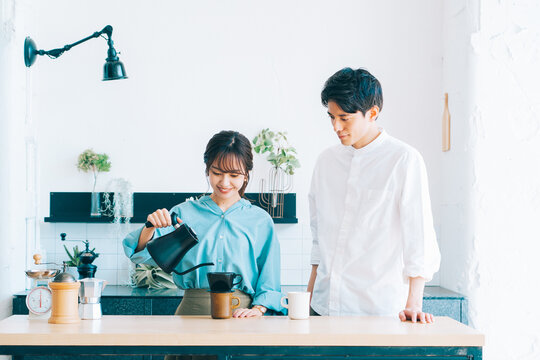 キッチンでコーヒーを入れる夫婦