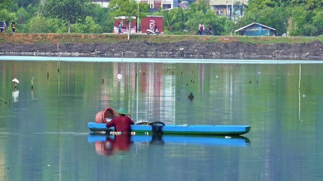 Traditional Fisherman Working in Small Wooden Boat Telephoto Shot