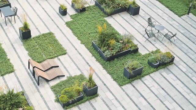 The garden area features wooden decking arranged with various potted plants and greenery. There are seating arrangements available for outdoor relaxation among the plants
