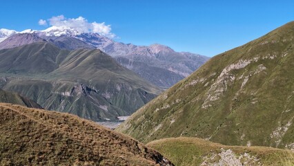 Mountain Valley Winding Toward Snow-Capped Peaks © OlenaK