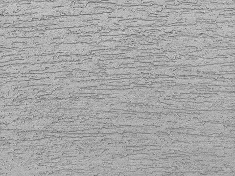 Close-up of grey textured plaster wall mimicking modern raw concrete.