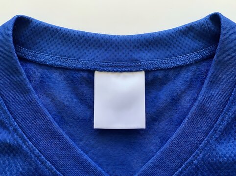 Close up of a blue jersey neckline with a blank white clothing label for branding and customization
