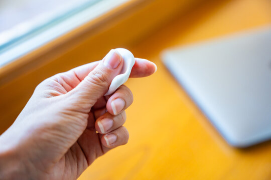 Woman squeezing stress relief putty while working at laptop. Sensory hand exercise helps reduce tension and manage stress during computer work