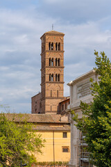 Obraz premium Ancient Roman bell tower with arched windows and colorful mosaic details against sky
