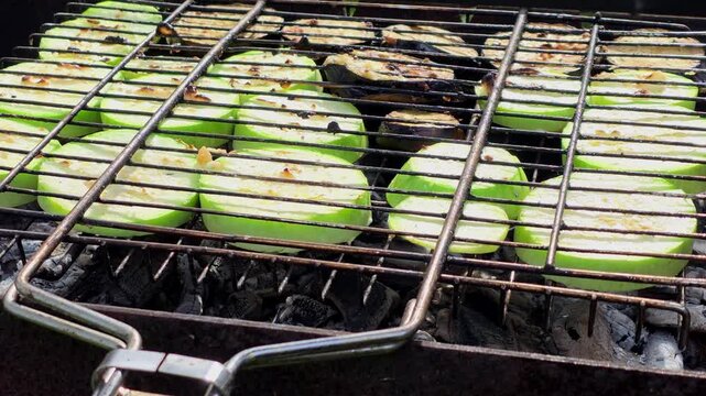 Grilling vegetables on an outdoor barbecue during a sunny day in a backyard setting