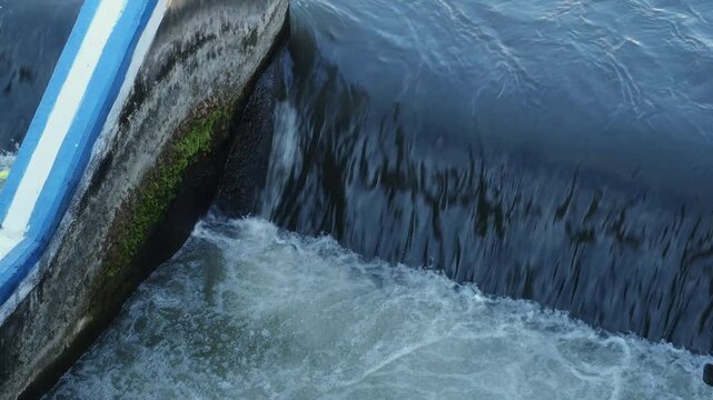 Water Cascading Over Concrete Rusty River Spillway Dam Lock Gate Hydroelectric Infrastructure, Swirling Dark Water Currents, and Waterway Engineering B-Roll. DAM river water dam gate.