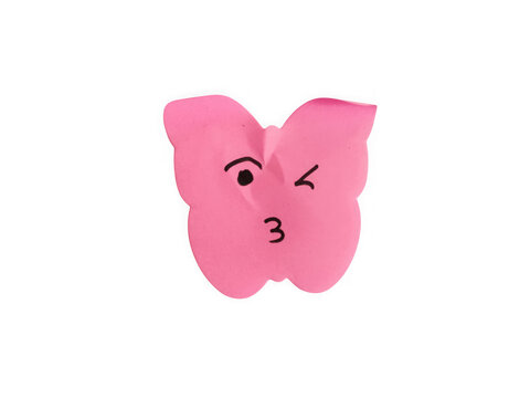 Pink paper note shaped like a butterfly with a winking face drawing isolated on transparent background