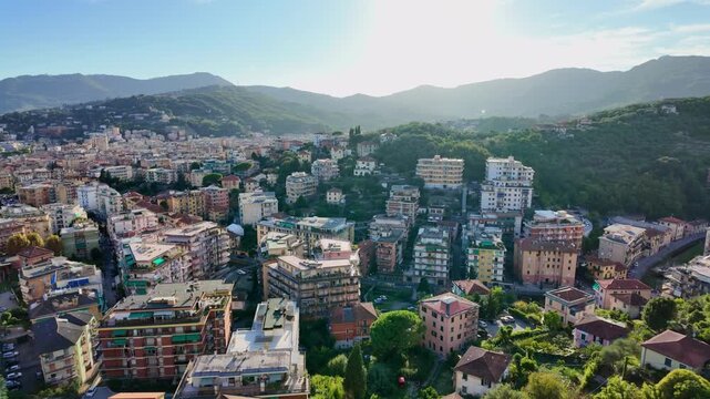Colorful hillside apartment buildings in residential neighborhood. Rapallo view from moving cable car in Italy