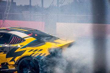 Drifting race car creating thick smoke during a competition event © shine.graphics