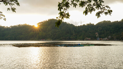 Sunrise Over Calm Lake with Mountain and Floating Fish Farm © czbchs
