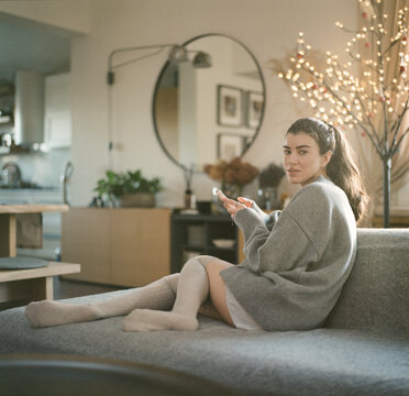 Young Woman Relaxing on Sofa at Home