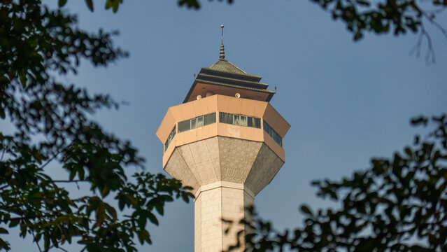 Tall Mosque Minaret Tower Framed by Tree Foliage