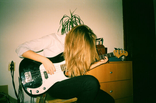 Person Playing Bass Guitar with Hair Covering Face