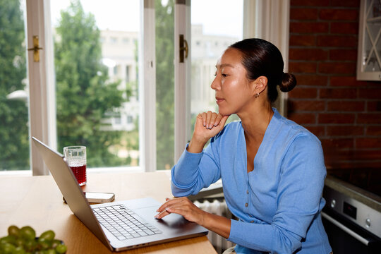 Woman works on a laptop at home