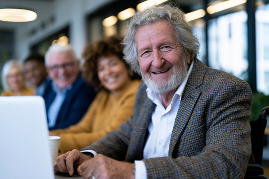 Diverse team of professionals collaborating around a modern conference table, inclusive workplace with different ages, ethnicities, genders and a wheelchair user actively contributing, bright