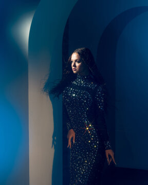 Minimal architecture and fashion, woman near a white arch with blue shadows, design concept.