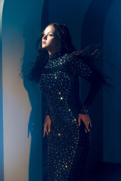 Cinematic fashion portrait of a woman looking away, blue arch shadows, magazine cover concept.