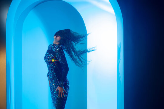 Music performance concept, woman in crystal dress with flying hair in a blue arch, wide banner.