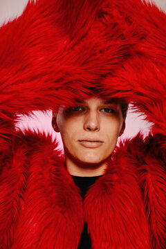Handsome young man in red fake fur coat