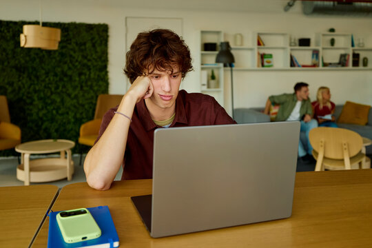 Young man studies in a shared university space.