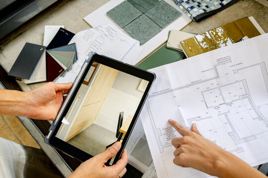 Anonymous Architect planning renovation with tablet and floor plan