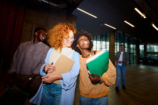 Happy classmates have fun inside the university building