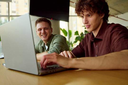 Friends Work Together on a Laptop in a Bright Office