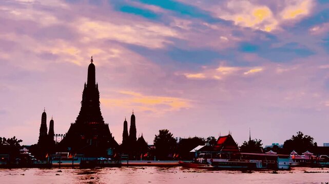 Silhouette of Wat Arun during a dramatic golden sunset over the Chao Phraya River in Bangkok, Thailand. Majestic temple structure framed by vibrant orange clouds and serene waters.