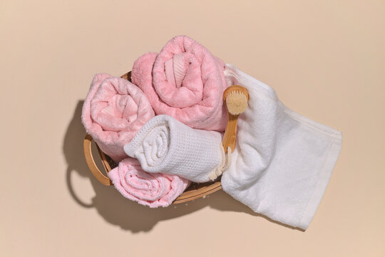 Rolled spa towels and facial brush in a basket
