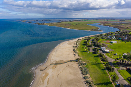 A sandy beach alongside a river winding out to sea