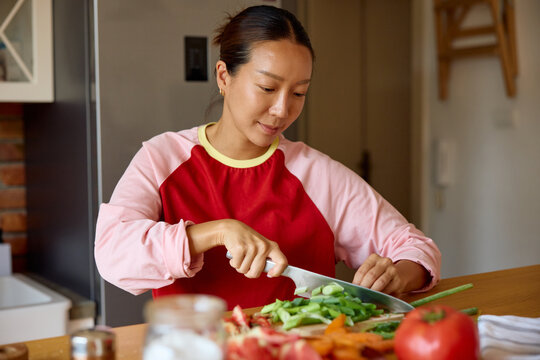 Woman chops fresh leek for the salad