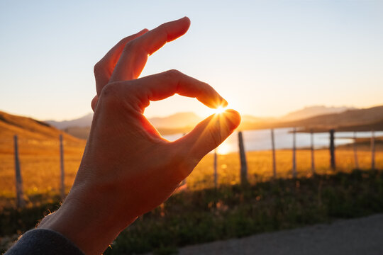 Hand Pinches Sun Between Finger and Thumb