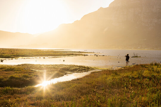 young boy exploring Lagoon  at sunset, Klein Mountains in background, Stanford, South Africa