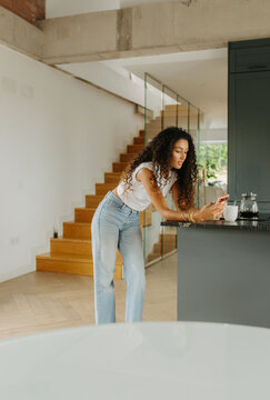 Woman Checking Phone At Counter