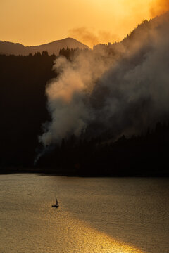 Airplane drops water on a wildfire from above.