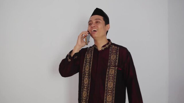 A Young Man Engaged in an Interesting Phone Conversation in Traditional Attire