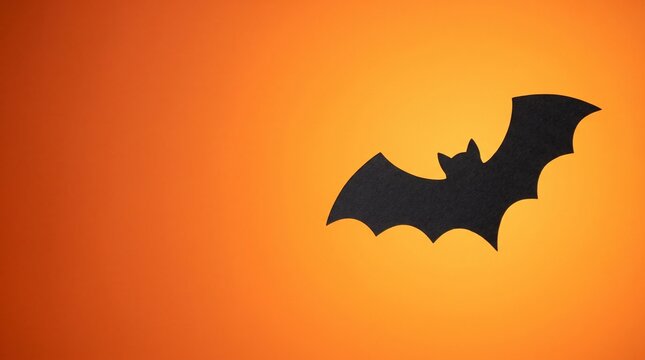 Black bat silhouette on a vibrant orange background with a gradient effect, perfect for Halloween themes