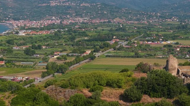 Torre di Velia Elea Velia Italy drone morning archaeological park Cilento Southern Italy, side tracking reveal ancient tower, green fields winding road, coastal town sandy beach turquoise sea
