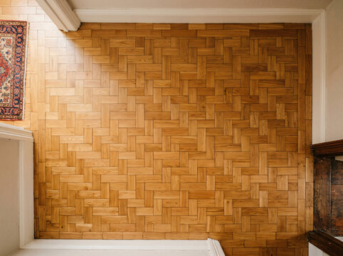 Classic basket weave parquet wood floor | High-angle view of vintage oak parquet flooring | Interior home design with traditional wood parquet pattern | Hardwood flooring installation and restoration 