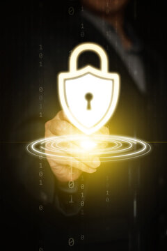 Cybersecurity concept. A businessman hand with stylus tapping at glowing shield padlock for system and data protection, privacy, security, and safety on vertical dark copy space. background.