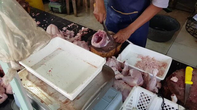Fresh chicken meat preparation and weighing at a traditional market.