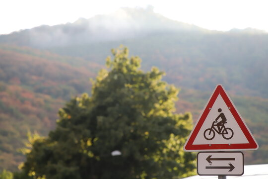Cyclist warning sign with mountain landscape