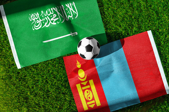 Saudi Arabia vs. Mongolia football match. National flags on green grass with soccer ball in the middle. Football background for international match.