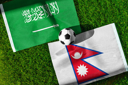 Saudi Arabia vs. Nepal football match. National flags on green grass with soccer ball in the middle. Football background for international match.