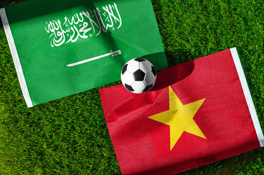 Saudi Arabia vs. Vietnam football match. National flags on green grass with soccer ball in the middle. Football background for international match.