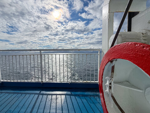 Ferry deck railing and the sunlit Baltic Sea