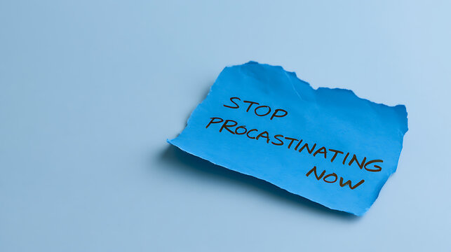 A blue torn piece of paper with hand written text message stop procrastinating now isolated on a light blue background for work project