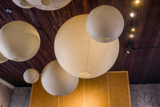 Traditional Asian white paper lantern on the ceiling in living room at home,detail of white Japanese Paper lamps,mediterranean design,home interiors,cozy house,Space for text.